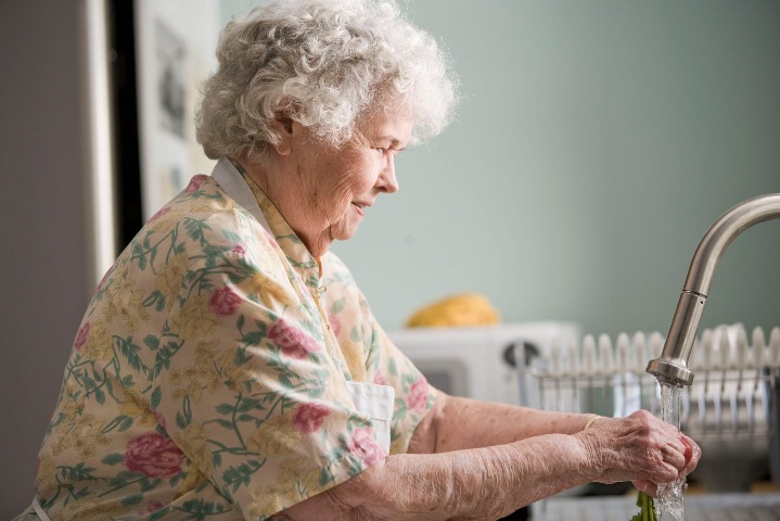 Elderly Woman Washing Vegetables