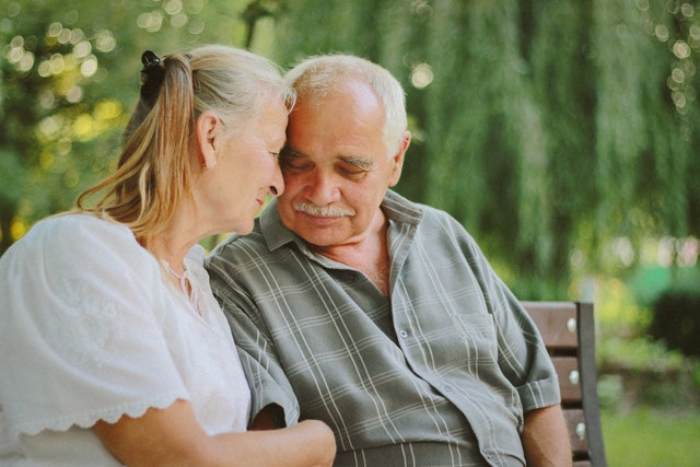 Elderly Couple Hugging on a Bench