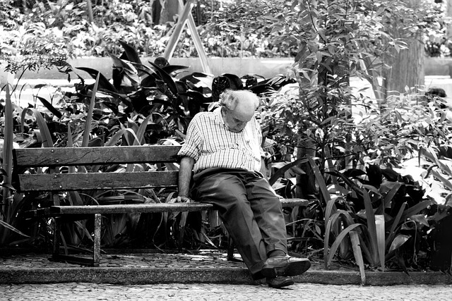 senior man sleeping on bench